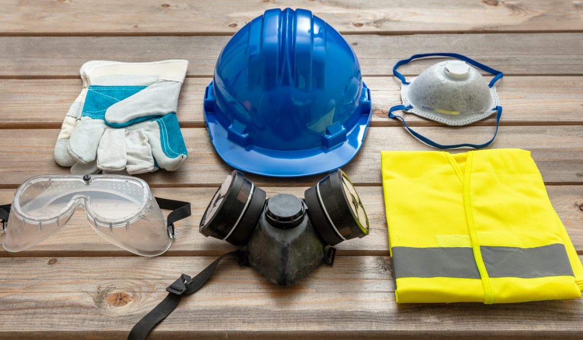 Work safety protection equipment on wooden background.